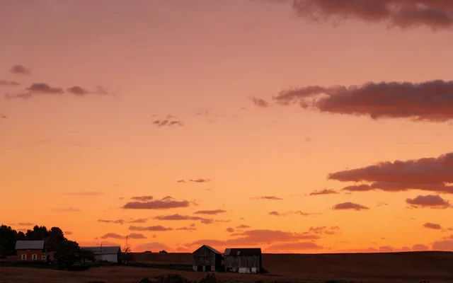 Um céu sem graça sobre uma quinta, trocado por um pôr do sol